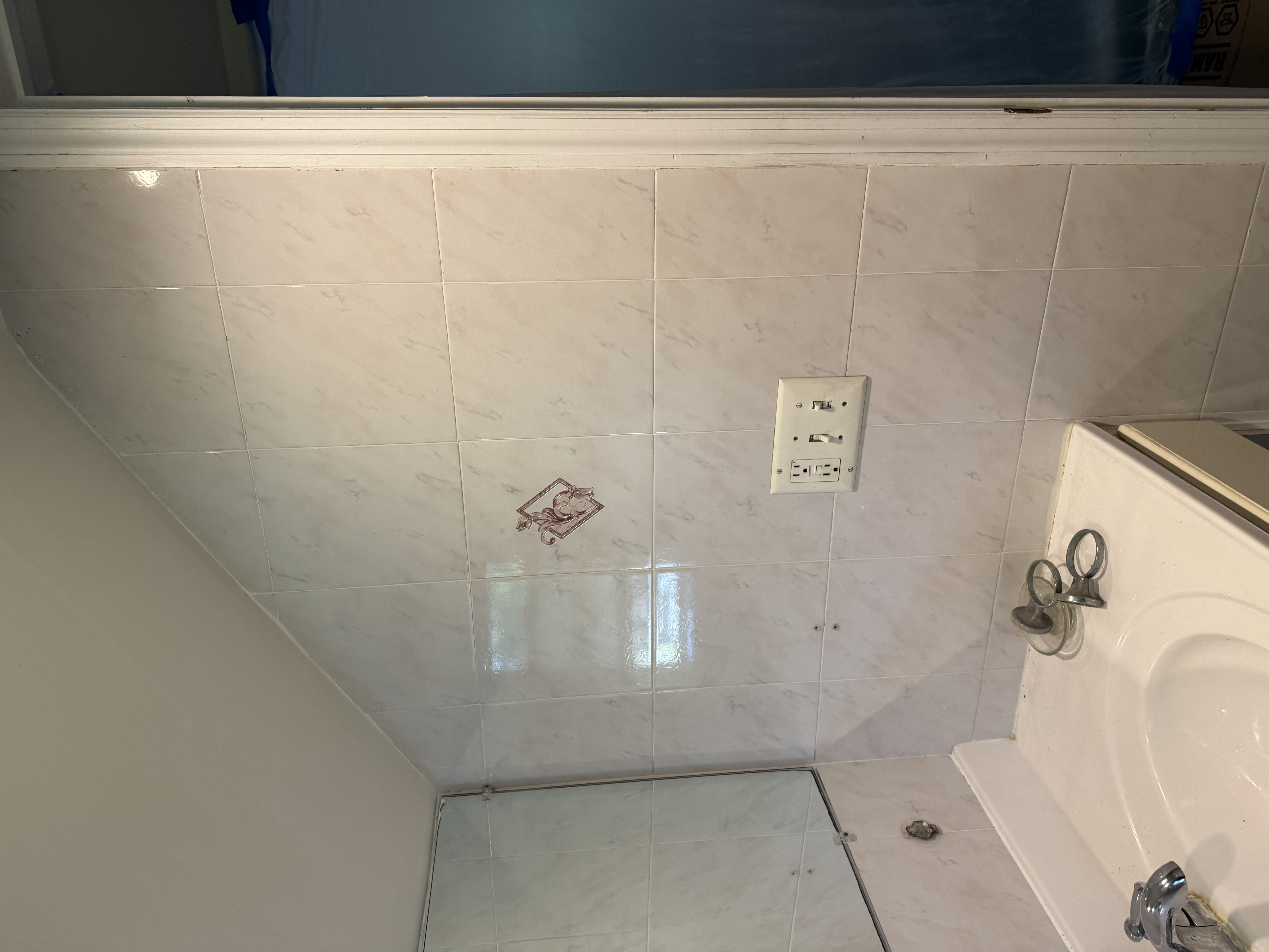 Bathroom featuring light marble-look wall tiles, vanity, mirror, chrome faucet, and electrical outlets after home renovation in [city], NJ.
