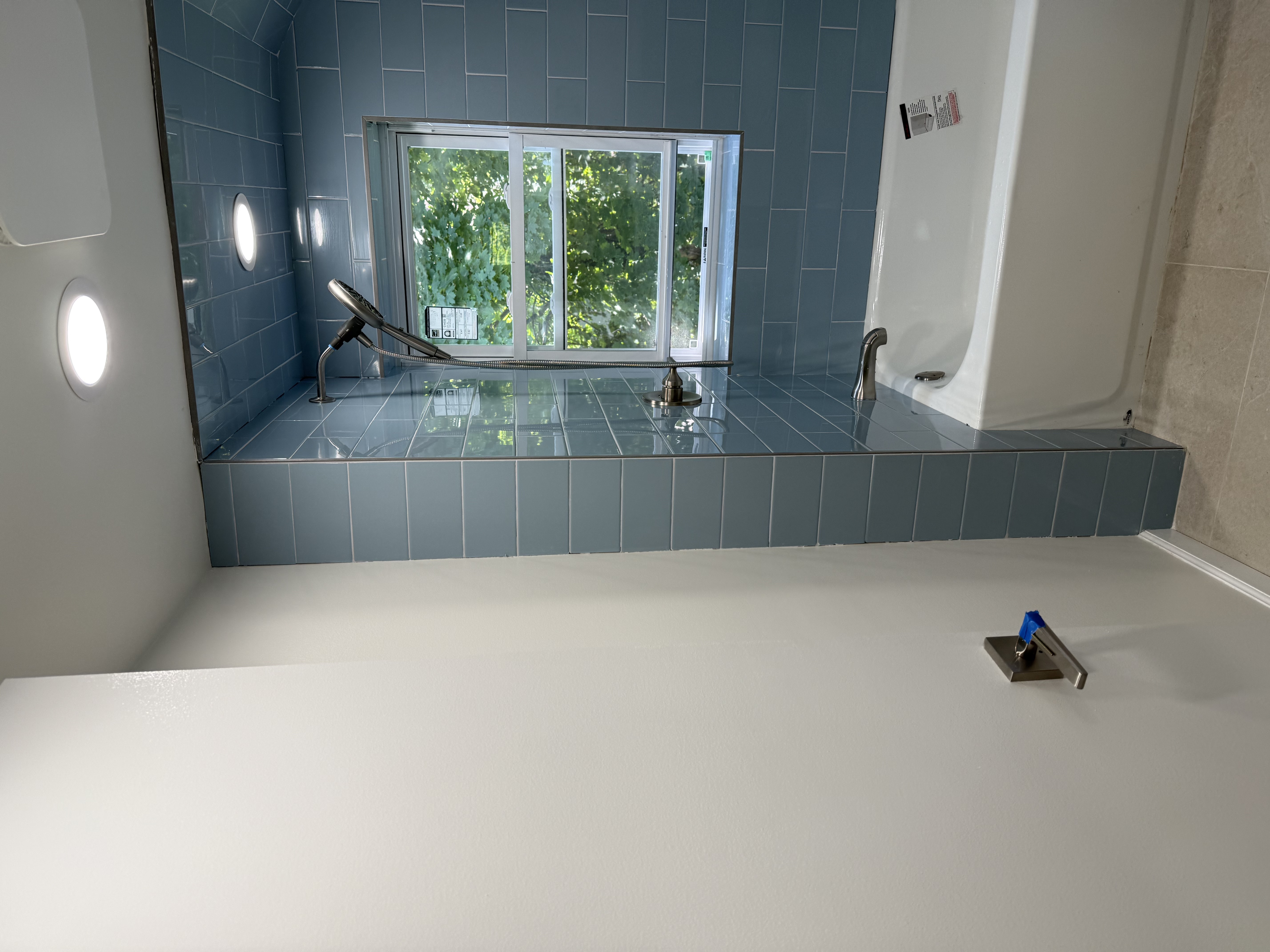 Bathroom featuring new blue subway tiles, white bathtub, brushed nickel fixtures, and recessed lighting after bath renovation in , NJ