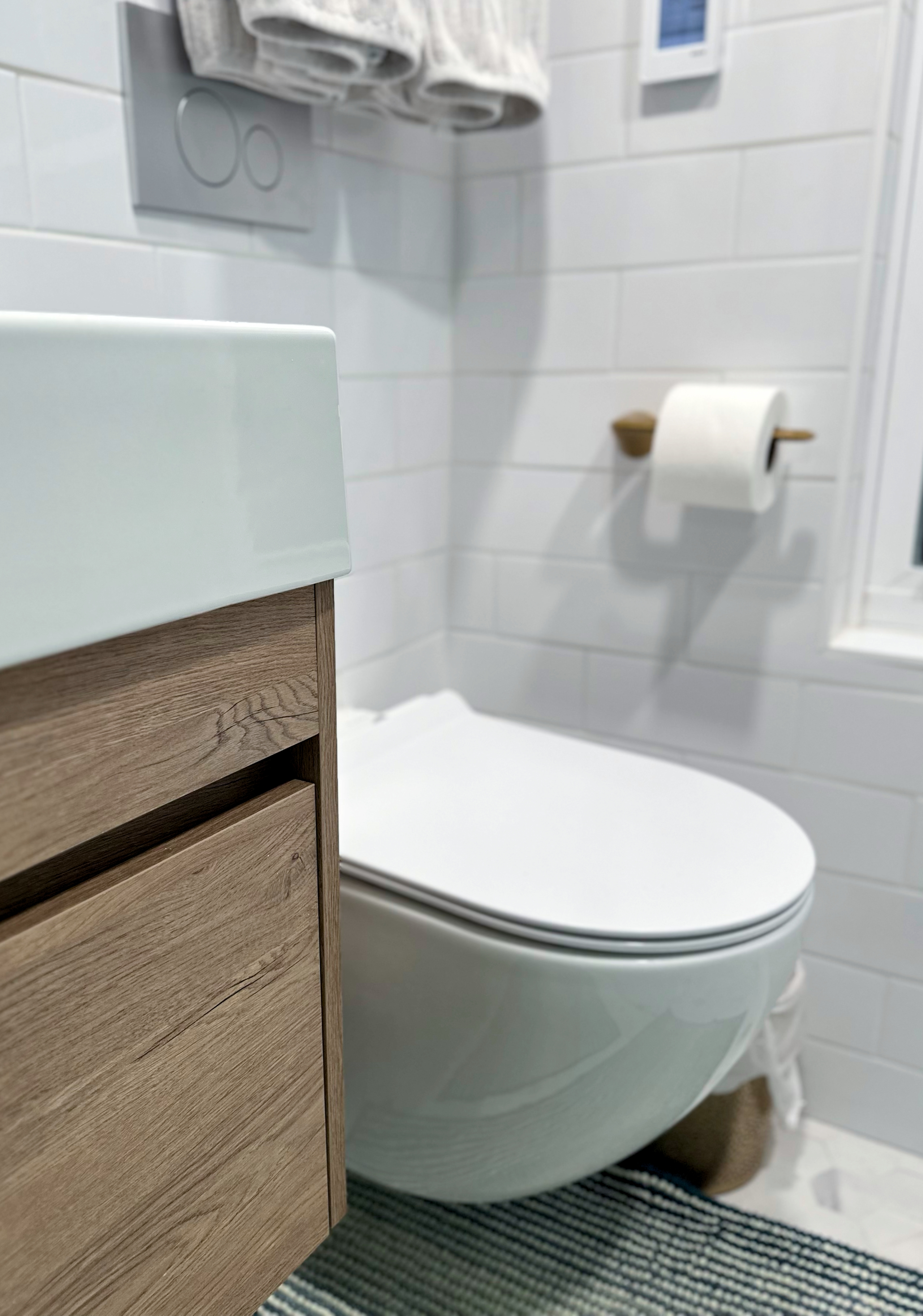 Modern bathroom with wood-look vanity, white subway tile walls, and a new toilet after Bathroom Renovation in Rahway, NJ.