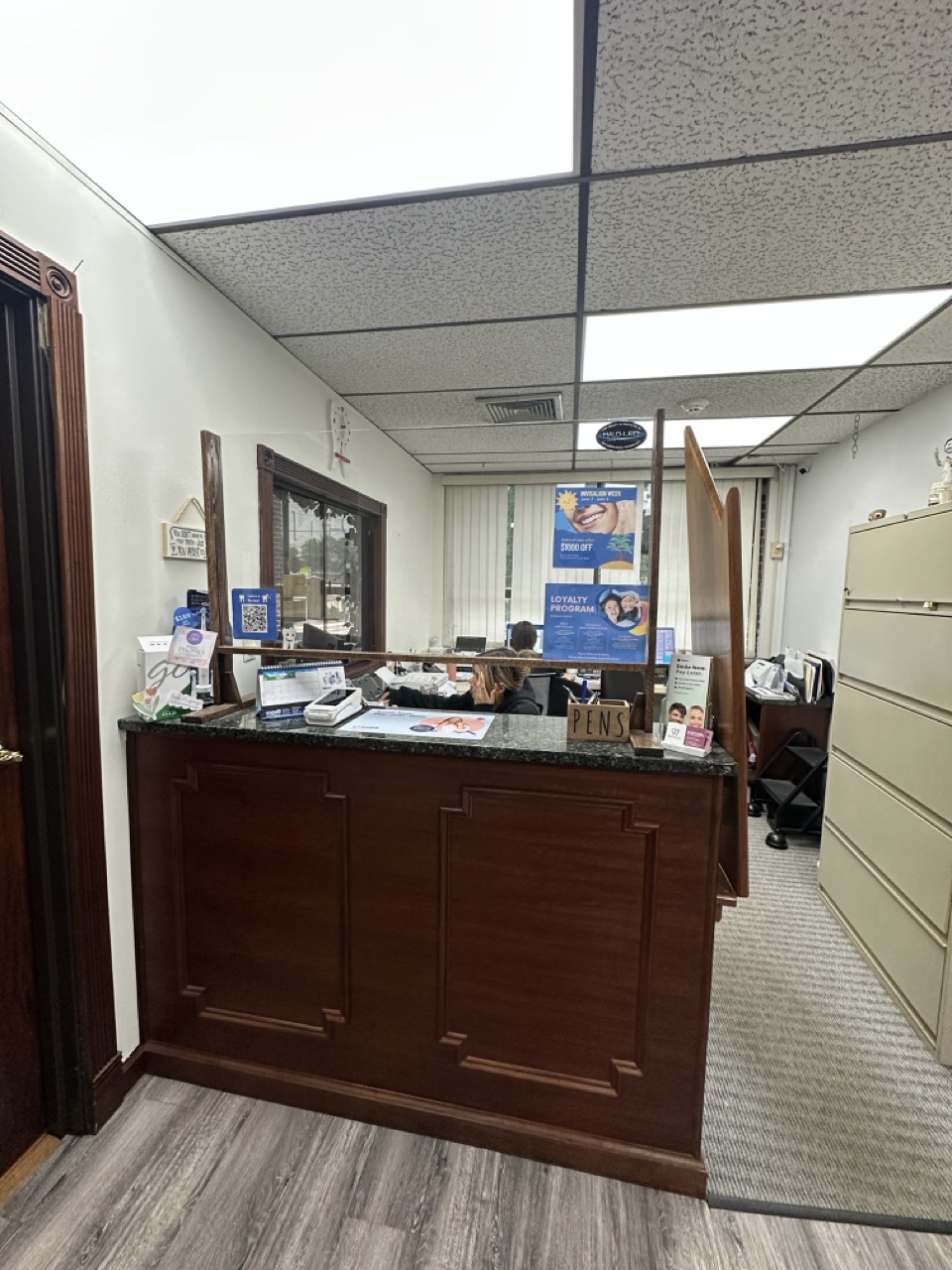Outdated office reception area with dark wood finishes