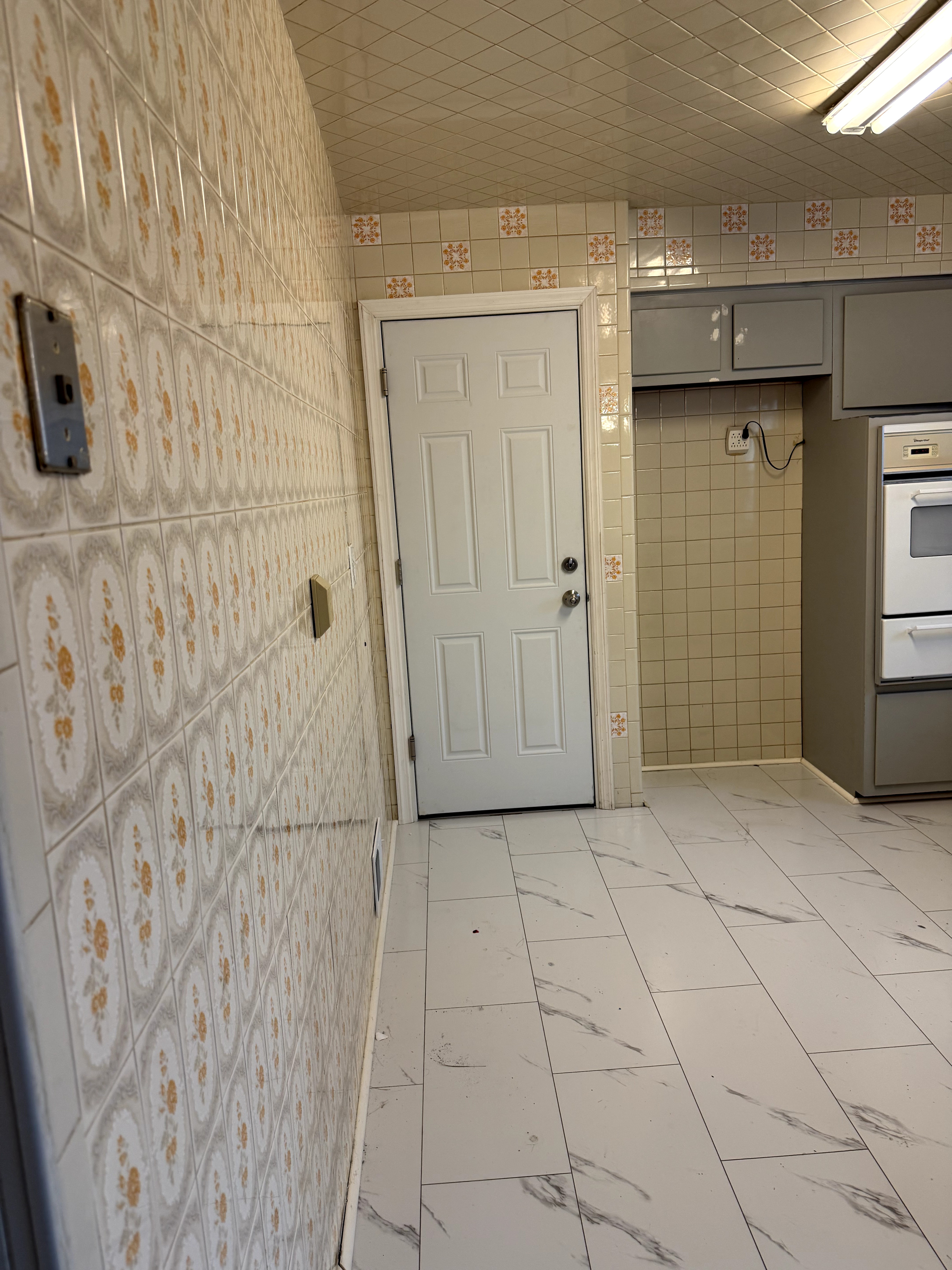 View of original kitchen entrance and dated wall tile