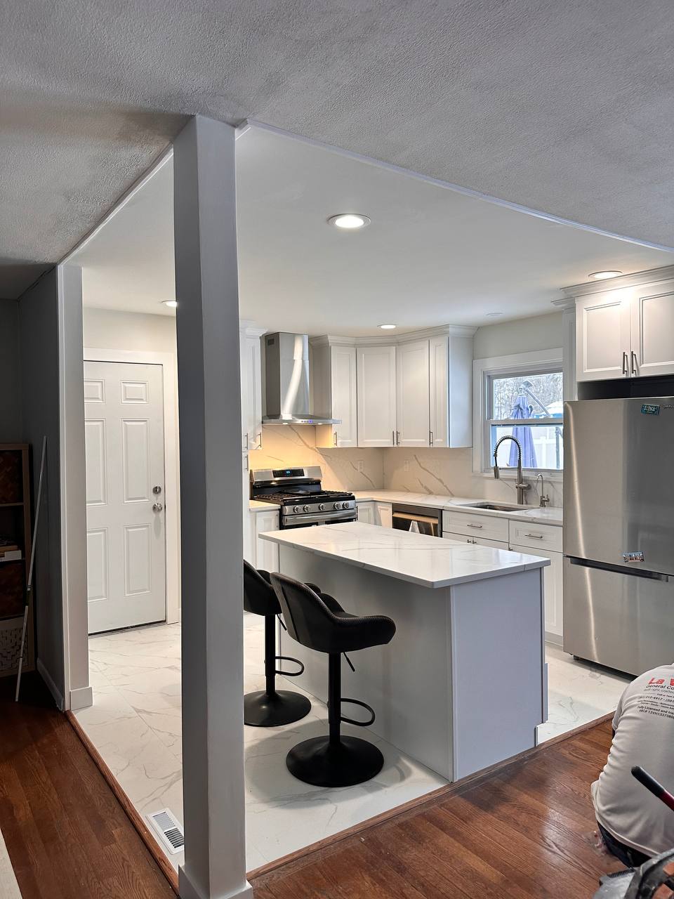 Renovated kitchen featuring a kitchen island and white cabinetry