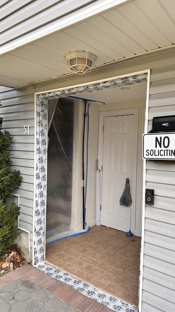Front entrance before renovation showing old door and plastic sheeting