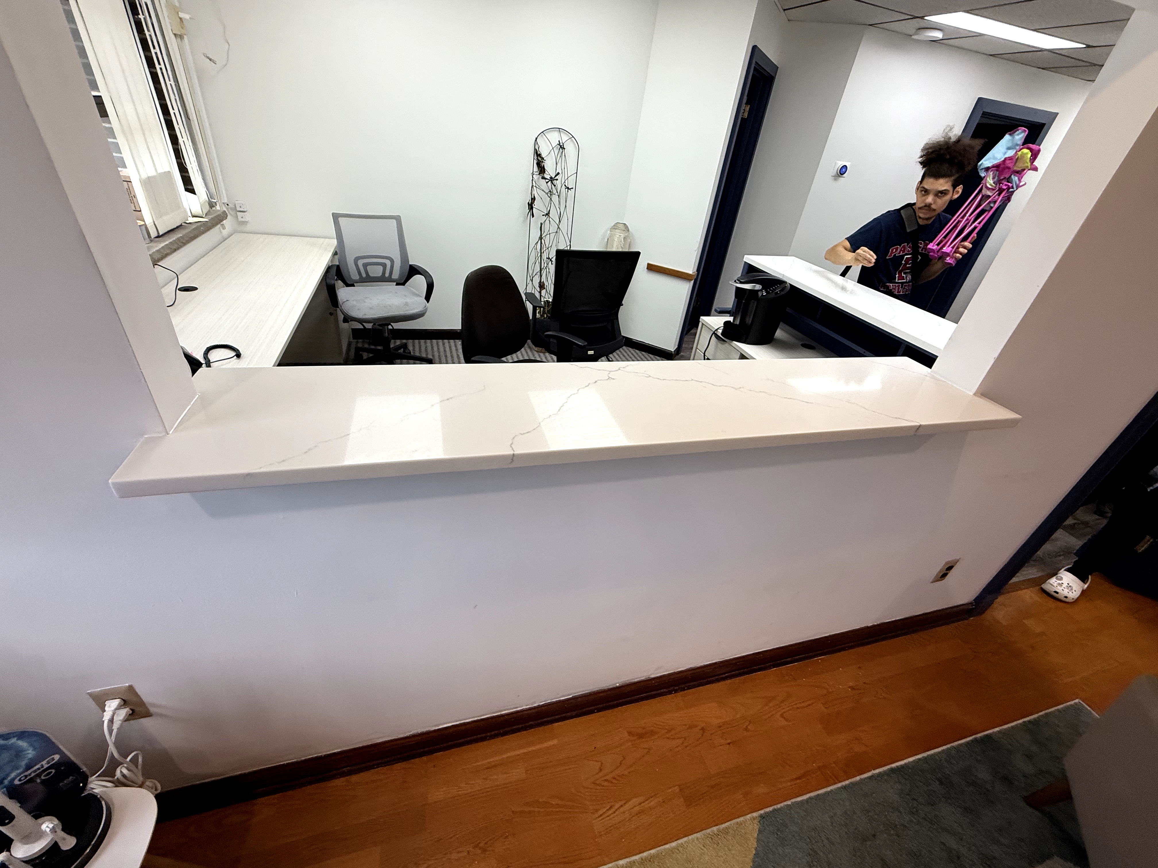 Office space with white quartz countertop and light wood desks after Custom Office Space redesign in Rochelle Park, NJ.