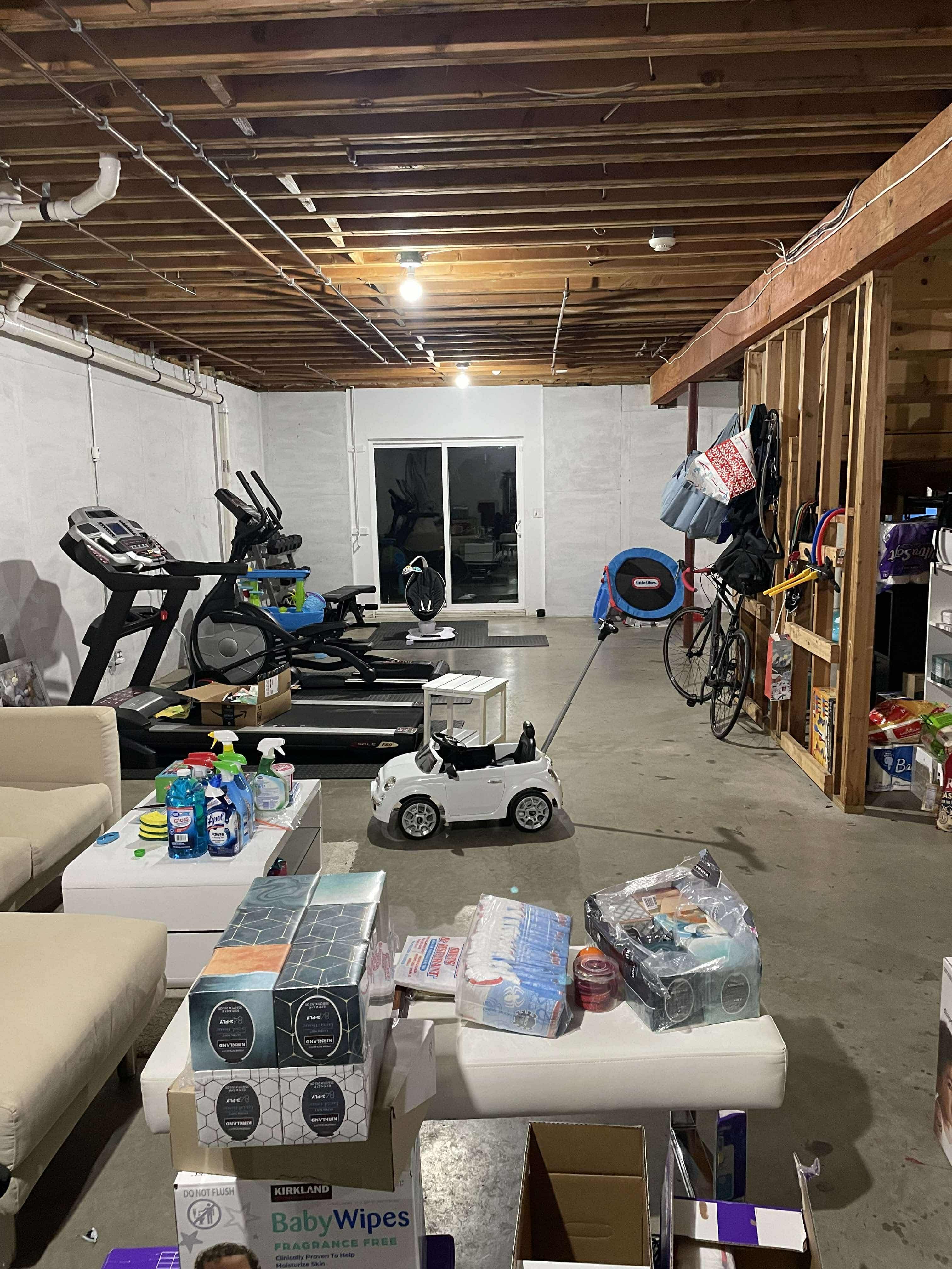 Unfinished basement in Kinnelon, NJ, with exposed wood beams, concrete walls/floor, and visible HVAC/plumbing, awaiting renovation.