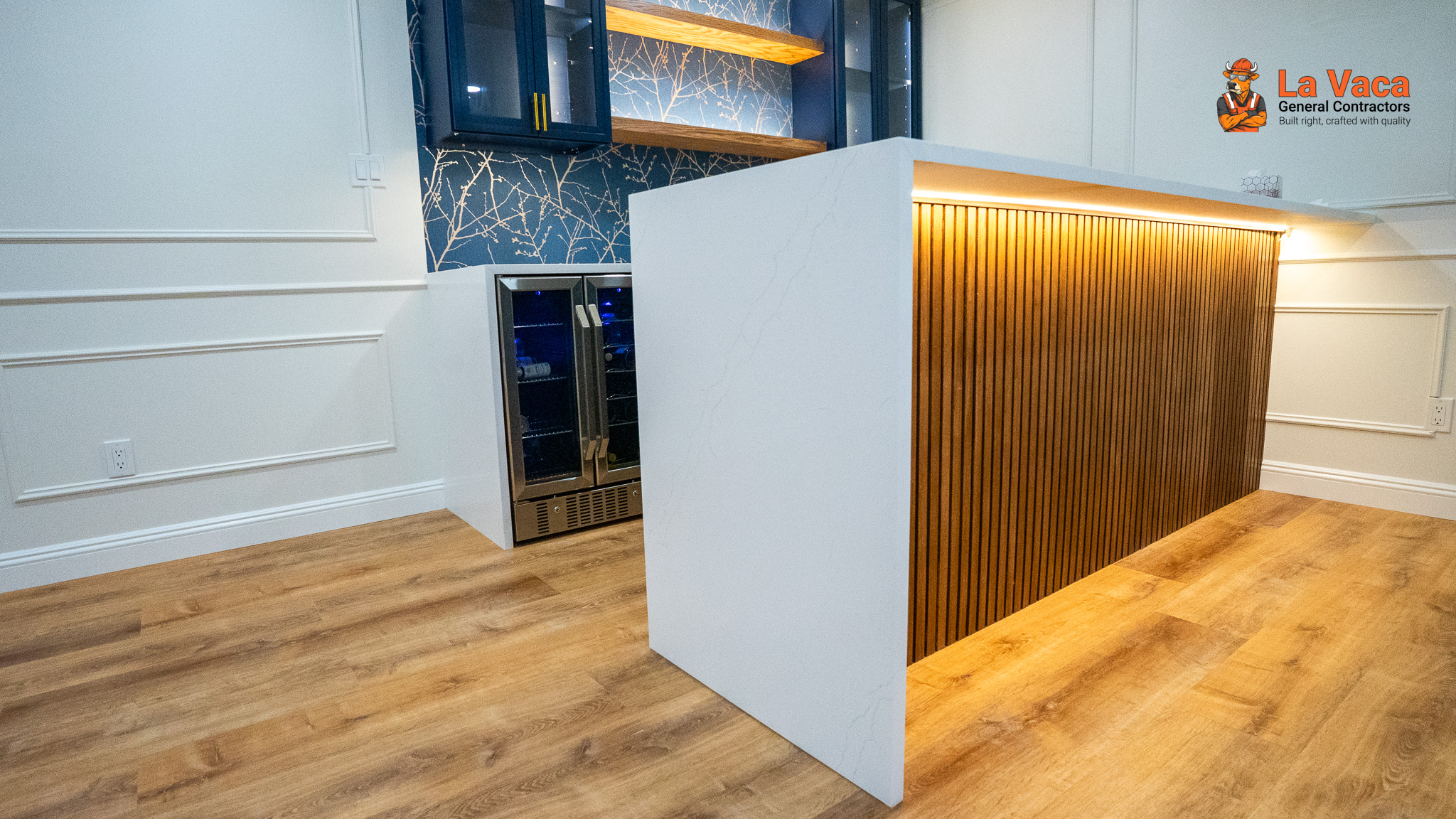 Basement bar with blue cabinets, quartz counter, wood paneling, beverage fridge, and light wood flooring after Basement Finishing in Kinnelon, NJ