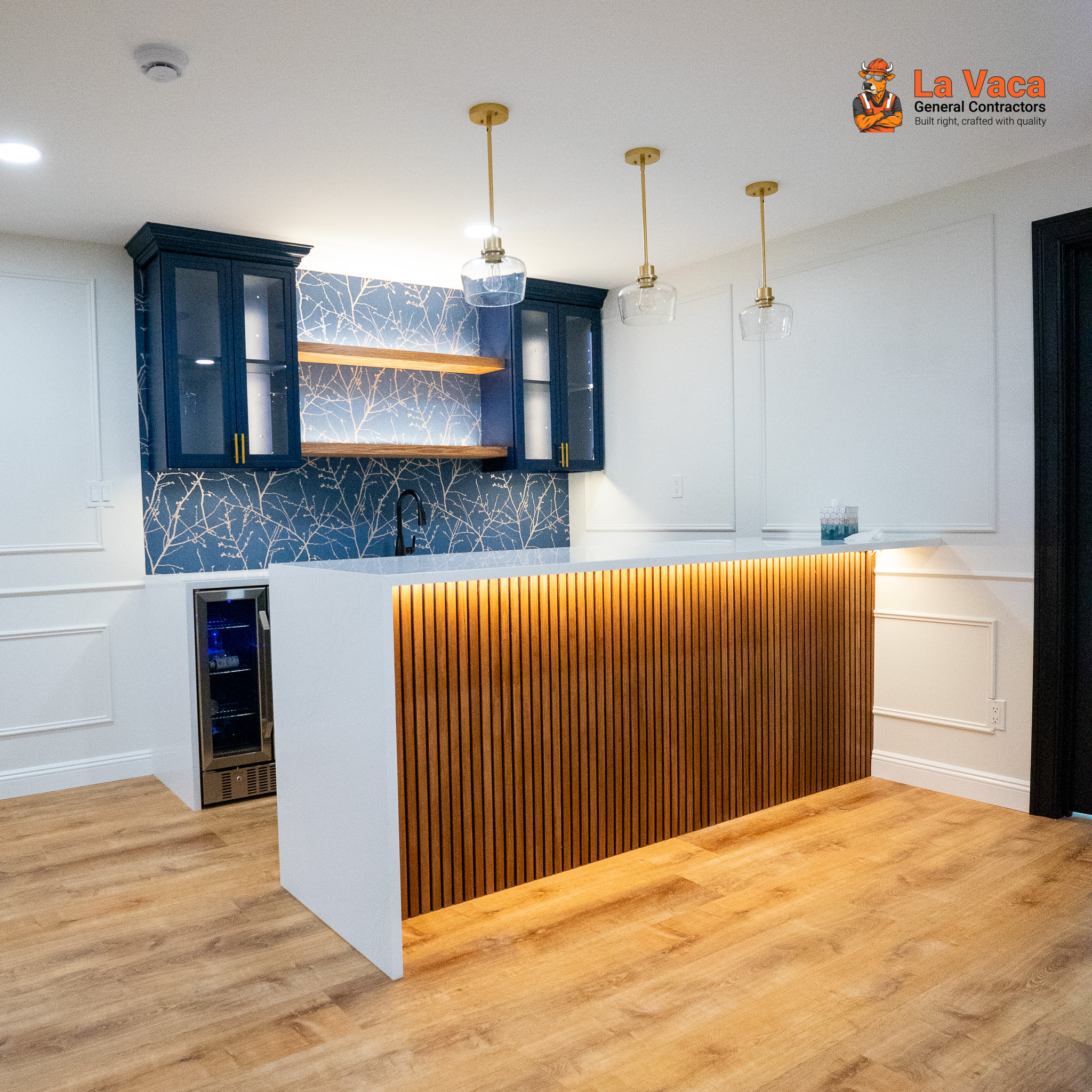 Custom wet bar with blue cabinets, wood shelving, and slatted bar island after Basement Finishing in Kinnelon, NJ.