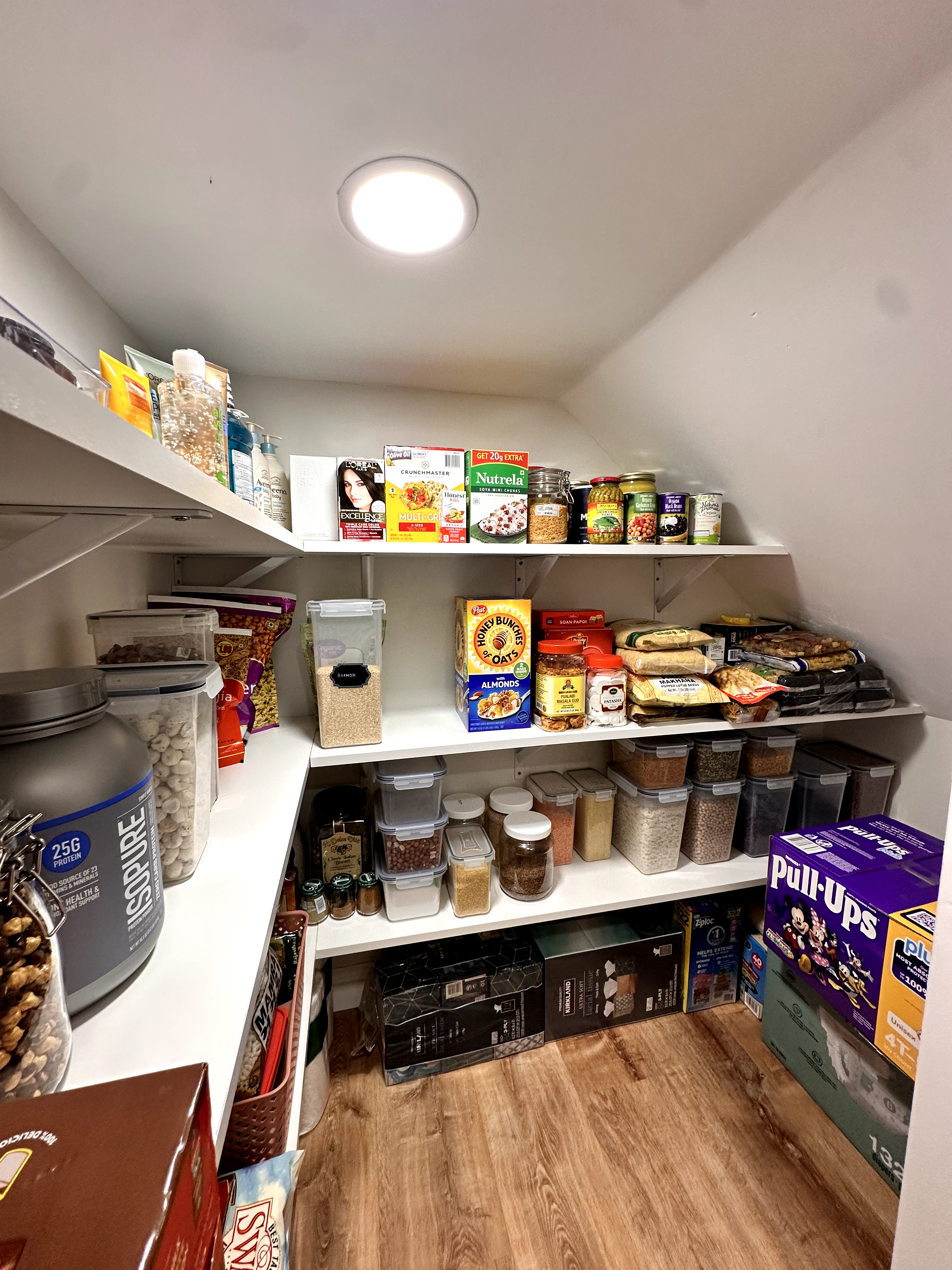 Pantry with white shelving, recessed lighting, and hardwood flooring, after Basement Finishing in Kinnelon, NJ.